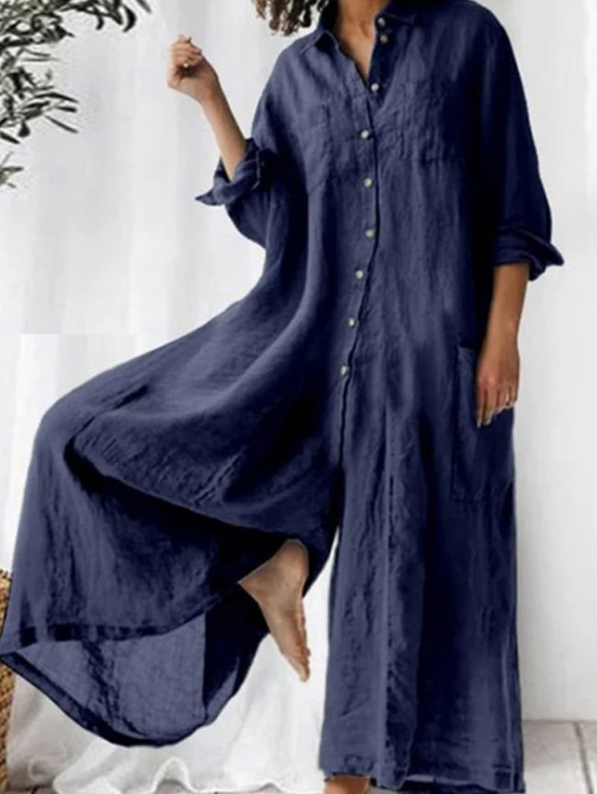 Avslappnad, enkel overall med krage, med en rad knappar och vida byxor