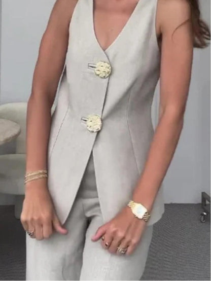 Kostym i två delar med väst med stora gyllene knappar och byxor