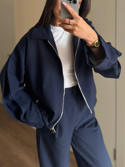 Kostym med jacka med dragkedja och utsvängda byxor