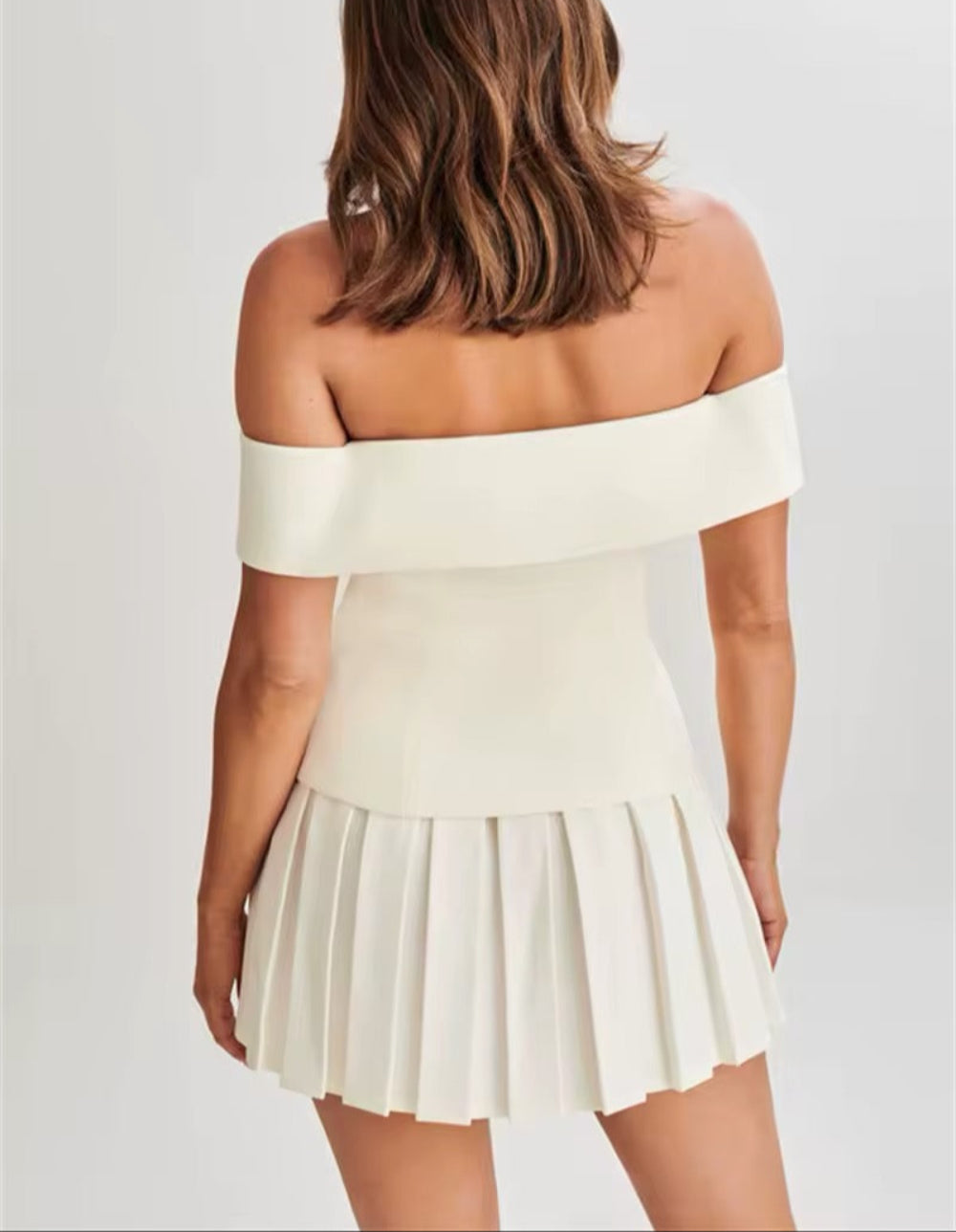 Top med avskuren axel och plisserad kjol