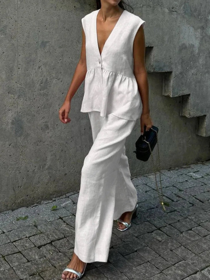 Kostym i bomull och linne, med V-ringning och volanger, bestående av två delar