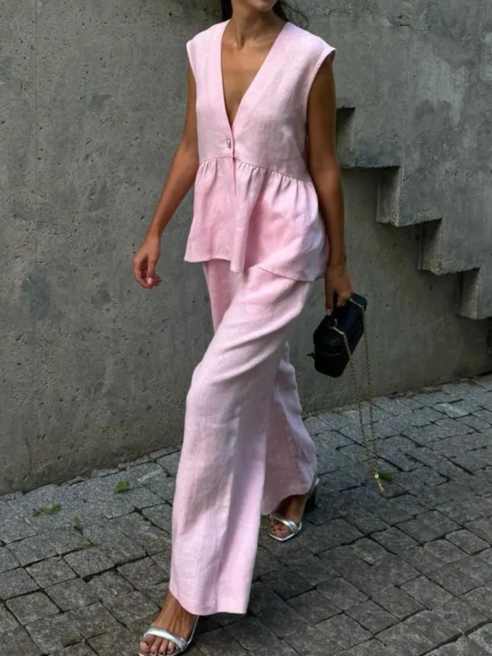 Kostym i bomull och linne, med V-ringning och volanger, bestående av två delar